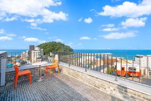 a balcony with a table and chairs and the ocean at Ingu Stay in Yangyang