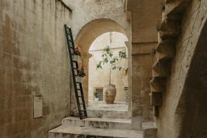 un callejón con escaleras y un jarrón en un edificio en L'Arturo B&B, en Matera