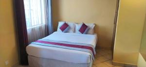 ein großes Bett in einem Zimmer mit Fenster in der Unterkunft Plus254 Hotel in Nairobi