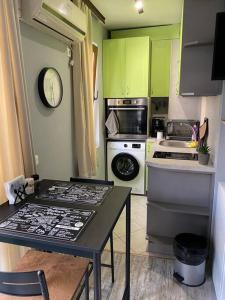 una pequeña cocina con armarios verdes y una mesa en Studio Dani - Levski, en Varna