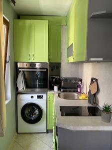 cocina con armarios verdes y lavadora en Studio Dani - Levski, en Varna