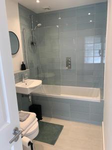 a bathroom with a shower and a tub and a sink at Executive Coach House on the Hoe 2 free parking spaces in Plymouth