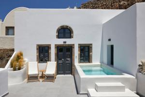 a white house with a swimming pool and chairs at Lerion Luxury Villas in Akrotiri