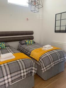 dwa łóżka siedzące obok siebie w pokoju w obiekcie Executive Coach House on the Hoe 2 free parking spaces w mieście Plymouth