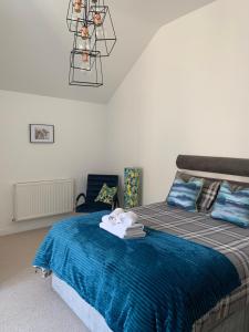 a bedroom with a bed with a blue blanket at Executive Coach House on the Hoe 2 free parking spaces in Plymouth
