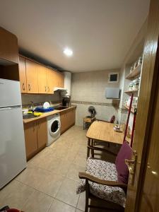 una piccola cucina con tavolo e frigorifero di PUERTA DEL SOL Carretas APARTAMENTS & Rooms a Madrid