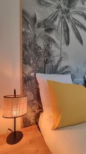 a bed with a lamp and a wall with palm trees at Bohemia - T2 Design avec Terrasse proche de Cassis in Roquefort-la-Bédoule