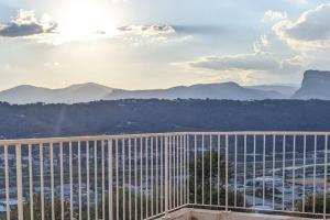 uma vista para as montanhas a partir de uma varanda de um edifício em 3 pièces dans villa avec piscine em Nice