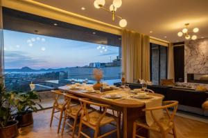 jadalnia ze stołem i dużym oknem w obiekcie Hills Deluxe - Relaxed Luxury in style and serenity w mieście Yalıkavak