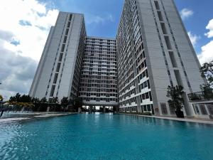a swimming pool in front of two tall buildings at Aha Horizon Suites in Sepang