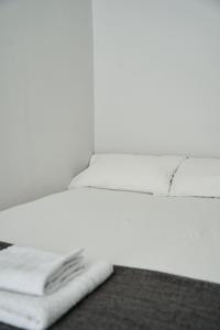 a white bed with a pile of towels on it at Douglas Gatehouse in Douglas