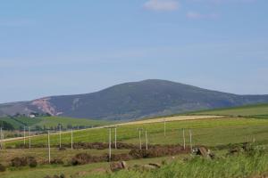 a green field with a mountain in the background at Douglas Gatehouse in Douglas