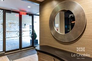 um espelho circular na parede de um edifício em Hotel Le Chablis Cadillac em Montréal
