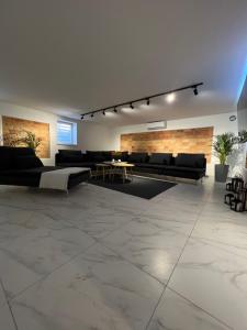uma sala de estar com mobiliário preto e uma parede de tijolos em Kierunek Górki 