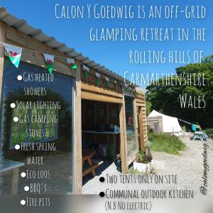 una señal para un retiro de acampada en las colinas ondulantes de la naturaleza canadiense en Calon Y Goedwig Glamping, en Llandovery