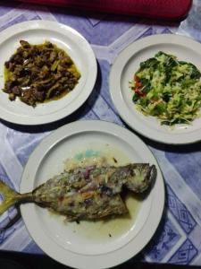 tres platos de comida con un pescado y una ensalada en Pondok Lestari Kadidiri, en Batudaka
