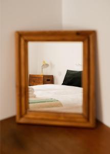 a mirror reflection of a bed in a bedroom at Casa do Lado in Vila Nova de Milfontes
