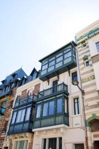 a building with a balcony on the side of it at Villa Adèle, vue mer, sauna et plage in Mers-les-Bains