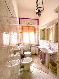 een badkamer met 2 wastafels en een toilet bij Appartamento Mareadi in Marina di Grosseto