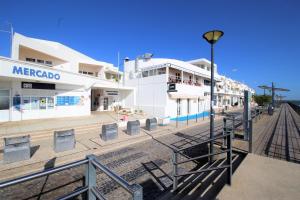 un gruppo di edifici su una strada con un lampione di Mimosa House Cabanas a Cabanas de Tavira