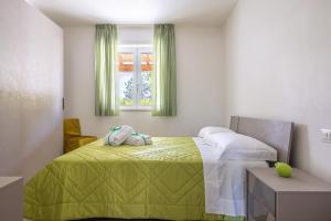 - une chambre avec un lit doté d'une couverture verte et d'une fenêtre dans l'établissement Color Dream Residence, à Monopoli