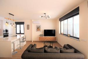 a living room with a couch and a kitchen at Mimosa House Cabanas in Cabanas de Tavira