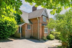 a brick house with a chimney on top of it at Lodge Farm - Stunning 3 Bed with Large Garden! in Beckley