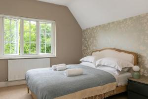 a bedroom with a bed with two pillows on it at Lodge Farm - Stunning 3 Bed with Large Garden! in Beckley