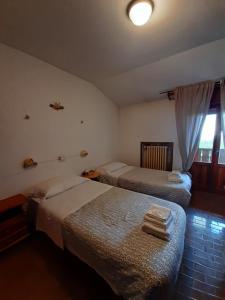 a hotel room with two beds and a window at Hotel Calvanella in Sestola