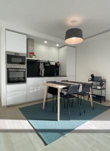 a kitchen with a table and chairs in a room at Blue House in Costa da Caparica