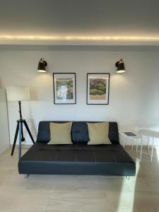 niebieska kanapa w pokoju z dwoma zdjęciami na ścianie w obiekcie Blue House w Costa de Caparica
