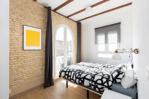 um quarto com uma cama e uma parede de tijolos em SB2 - Apartamento moderno 2 dormitorios, 4º sin ascensor, muy céntrico em Zaragoza