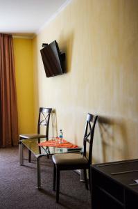 a room with a table and two chairs and a tv at Hotel Marinara in Odesa +100 photos