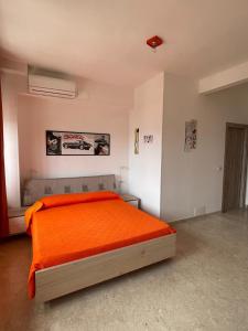 une chambre avec un lit avec une couverture orange dans l'établissement La finestra sul mare B&B, à Crotone