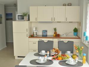 a kitchen with a table with a plate of fruit at Whg 09 - Fischerstuv in Zingst