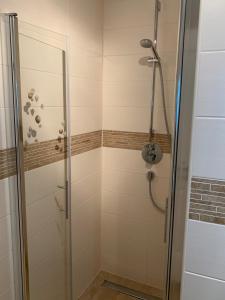 a shower with a glass door in a bathroom at Whg 09 - Fischerstuv in Zingst