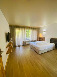 a large bedroom with a bed and a large window at L-DOM in Metzingen