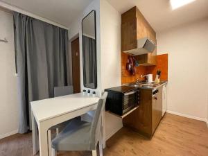 a small kitchen with a white table and a sink at Relaxing Loft Haven near Zermatt - Parking Free in Täsch