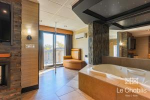 Habitación con baño grande con bañera. en Hotel Le Chablis Cadillac en Montreal