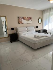 a bedroom with a large bed and a mirror at Appartamento Golfo di Solcio in Lesa