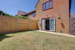 a brick house with a fence and a yard at Windham Mews - Stunning Flat in Seaside Town in Bournemouth