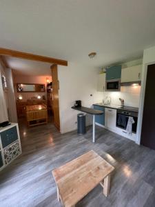 a living room with a table and a kitchen at Bonheur des Orres 1650 in Les Orres