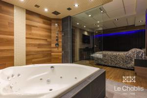 Hotel Le Chablis Cadillac في مونتريال: حوض استحمام كبير في حمام مع غرفة نوم +62 صورة