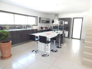 eine Küche mit einem weißen Tisch und schwarzen Schränken in der Unterkunft Villa proche de Montpellier et des plages in Castelnau-le-Lez