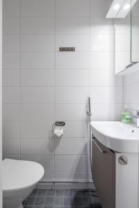 a white bathroom with a sink and a toilet at 2ndhomes Tampere "Ruuskanen" Apartment - 3 Bedrooms, Best Location & Sauna in Tampere