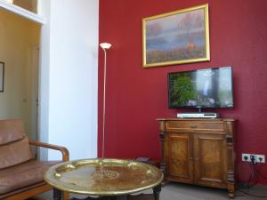 un soggiorno con TV e tavolo di Schloss Hohenzollern - Fewo mit Meerblick a Ahlbeck