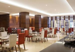 a dining room with tables and chairs in a restaurant at Four Points by Sheraton Makassar in Makassar