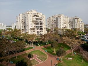 a park in front of a city with tall buildings at Cozy apartment with good vibe in Ashdod