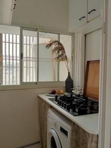 a kitchen with a stove and a washing machine at Cozy apartment with good vibe in Ashdod