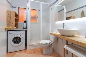 een badkamer met een wasmachine en een wastafel bij Àtic Brisa Mar in L'Estartit